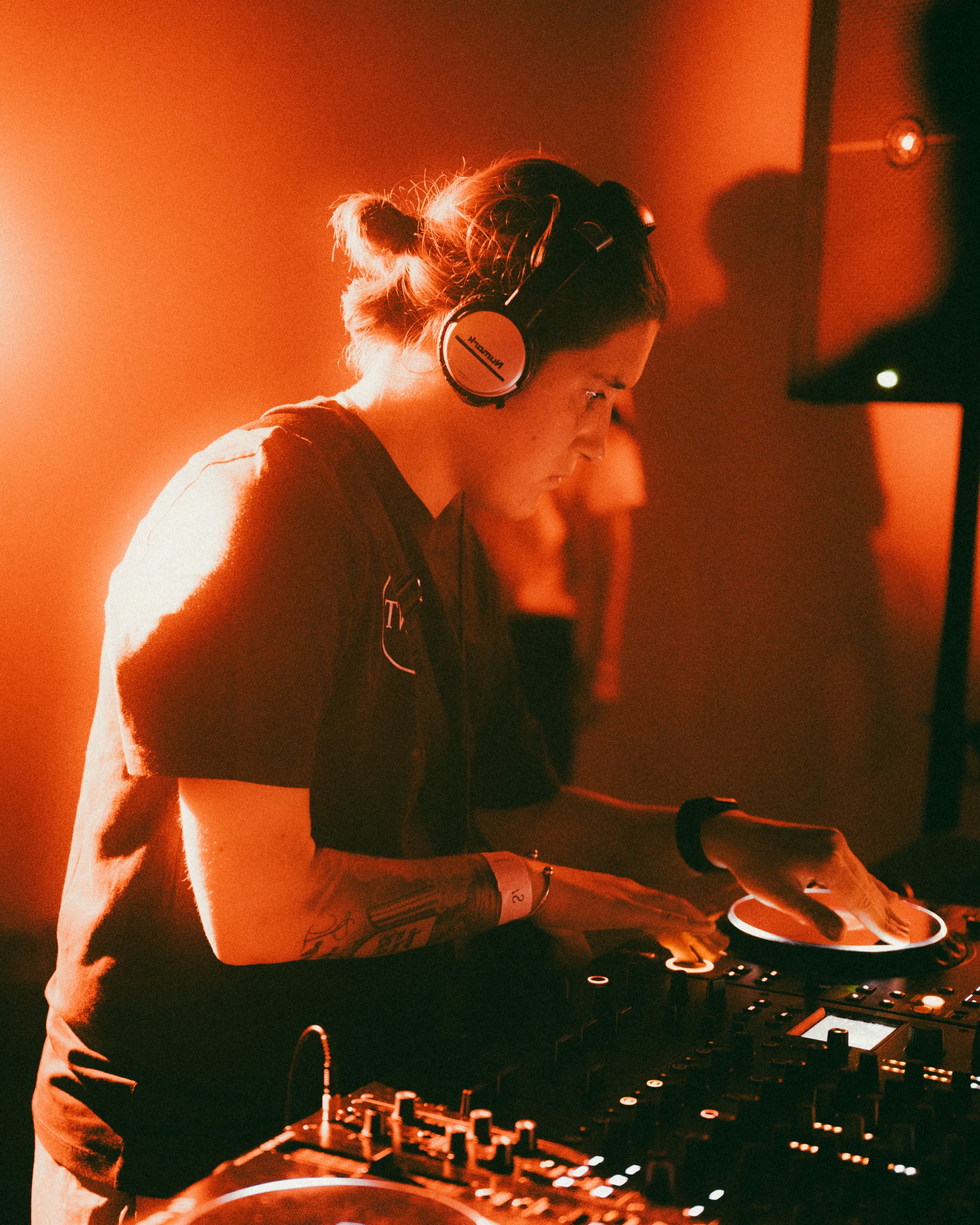 DJ performing beneath orange event light